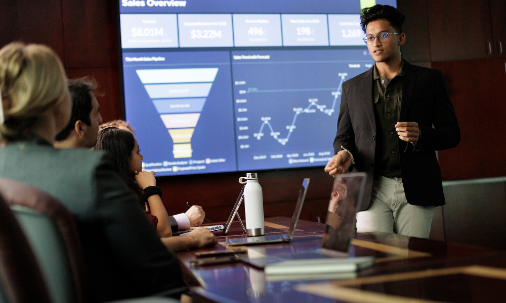 A business student presents sales figures in a boardroom