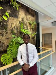 Student standing against the living wall