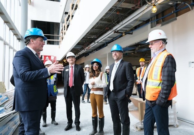 A group of people tour a construction site on campus
