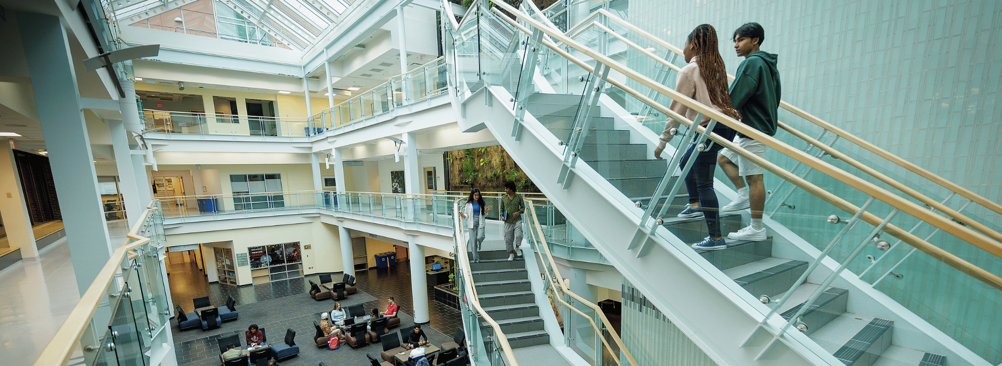 People walking and sitting inside the campus Atrium building