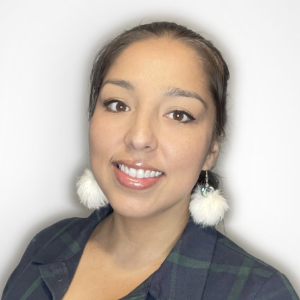 A woman posing for a photo, smiling with a white background.